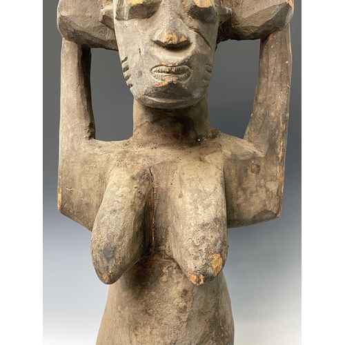 245 - A large African carved wood statue of a female figure holding a bowl above her head. Height 89cm