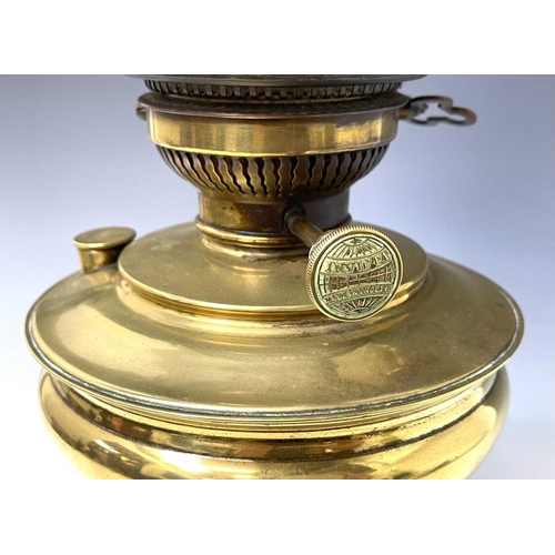 246 - A Victorian 'Invicta' brass oil lamp, raised on circular glazed black ceramic base, with white opaqu... 