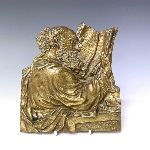 252 - A Victorian brass plaque, cast as a philosopher reading a book, height 18cm.