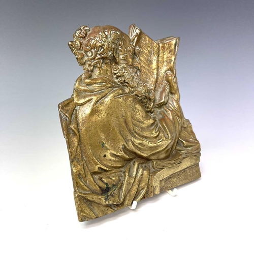 252 - A Victorian brass plaque, cast as a philosopher reading a book, height 18cm.