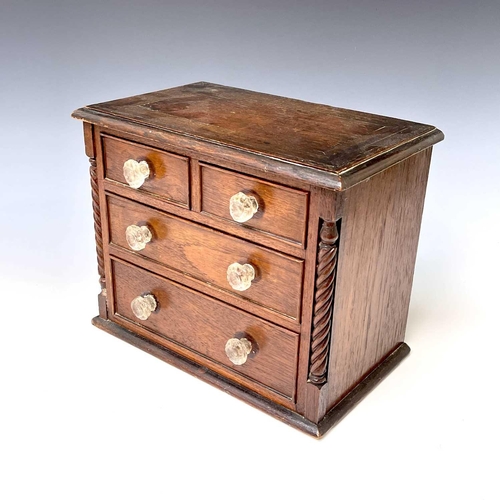 253 - A Victorian walnut apprentice chest of two short and two long drawers, with twist turned stiles, sta... 