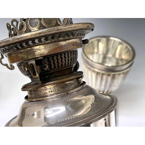 26 - An Edwardian silver plated urn shaped table oil lamp, with Hink's patent burner and with an etched g... 