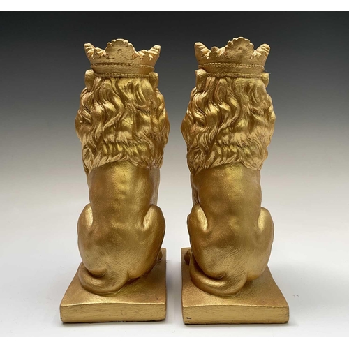 268 - A pair of gold painted seated lions wearing crowns. Height 35cm.