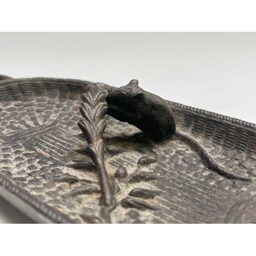 276 - A 20th century cast bronze sculpture of a mouse eating a sheaf of corn in a basket. Width 17.5cm.