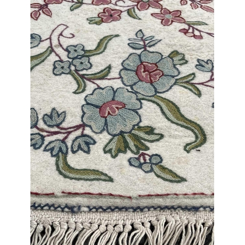 2800 - A cream ground rug/wall hanging with floral crewelwork decoration. 177 x 118.5cm.