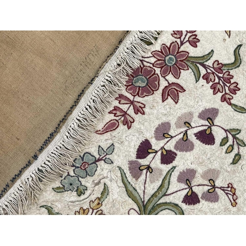 2800 - A cream ground rug/wall hanging with floral crewelwork decoration. 177 x 118.5cm.