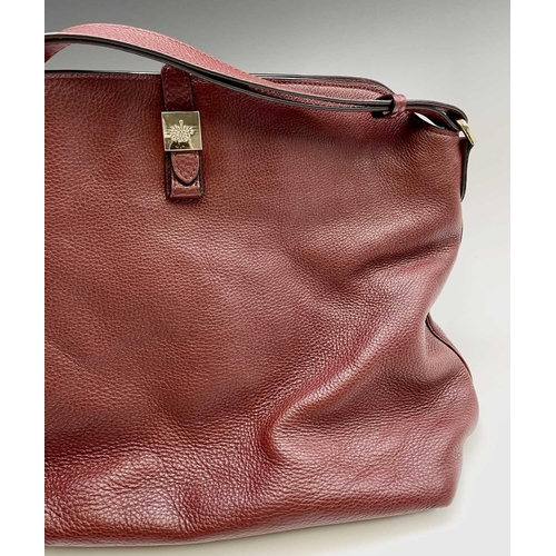 2827 - A Mulberry grained red leather handbag with gold coloured hardware. 32cm x 44cm (excluding strap).