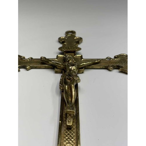 283 - A 20th century cast brass wall hanging crucifix, height 32cm, together with two large prints of a re... 