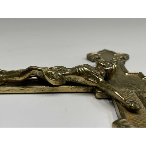 283 - A 20th century cast brass wall hanging crucifix, height 32cm, together with two large prints of a re... 