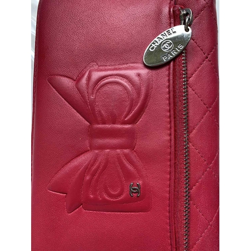 2832 - Chanel. Cerise pink lambskin leather wallet, embossed bow design to reverse, grey silver hardware, w... 