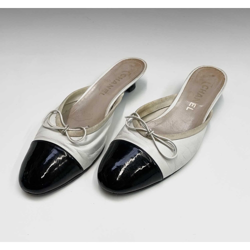 2834 - Chanel Shoes. Classic Chanel two tone kitten heel mules. White leather, with white bow, silk trim an... 