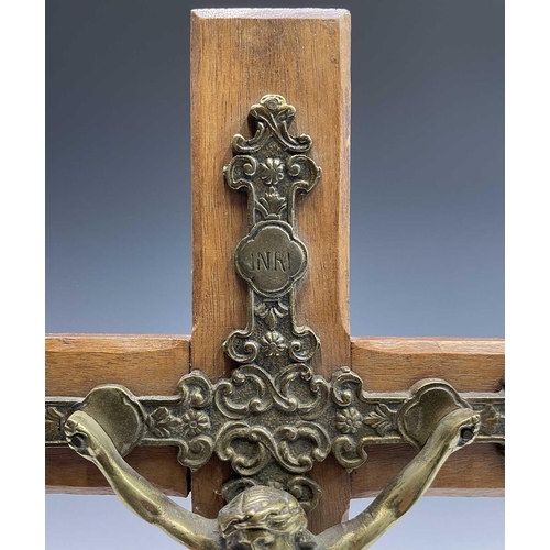 284 - A mid century oak mounted cast brass wall hanging crucifix. Overall height 47.5cm.