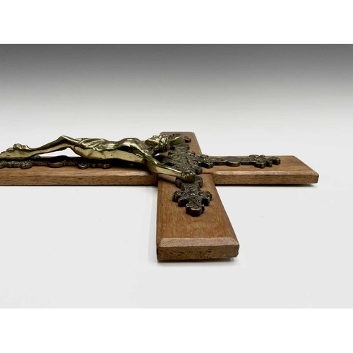 284 - A mid century oak mounted cast brass wall hanging crucifix. Overall height 47.5cm.