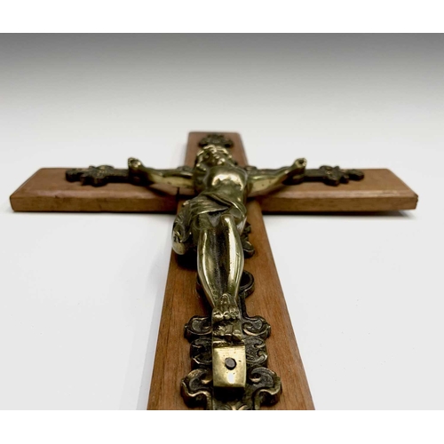 284 - A mid century oak mounted cast brass wall hanging crucifix. Overall height 47.5cm.