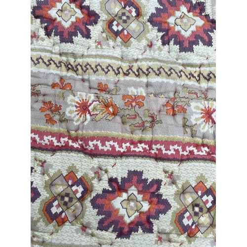 2857 - A heavy and thick red floral quilt together with a machine made tapestry style panel. The quilt 210x... 