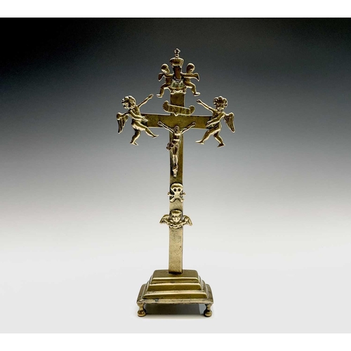 286 - A brass altar crucifix, cast with the figure of Christ beneath an INRI scroll, cherubim, and a skull... 