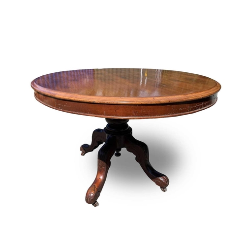 3001 - A Victorian mahogany tilt top oval table, raised on a turned column and leaf carved quadruped base. ... 