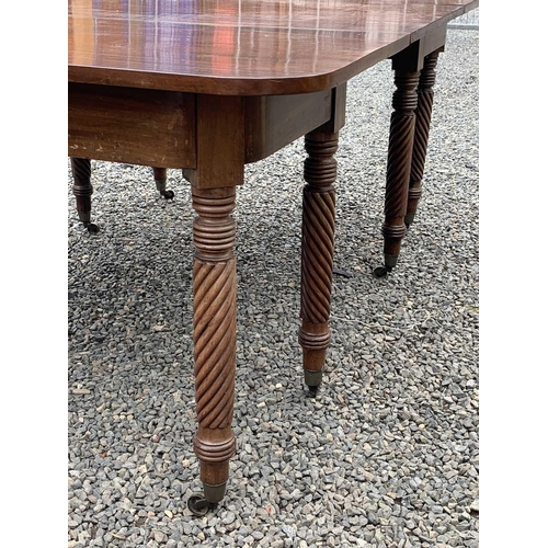 3028 - A Regency mahogany extending dining table, with two D ends and an additional leaf, raised on spiral ... 