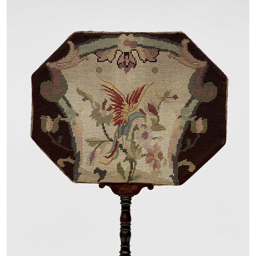 3030 - A Regency rosewood pole screen, with octagonal woolwork panel depicting an exotic bird amongst folia... 