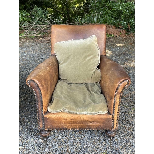 3040 - A pair of leather-upholstered club-type armchairs with studded decoration and raised on turned front... 