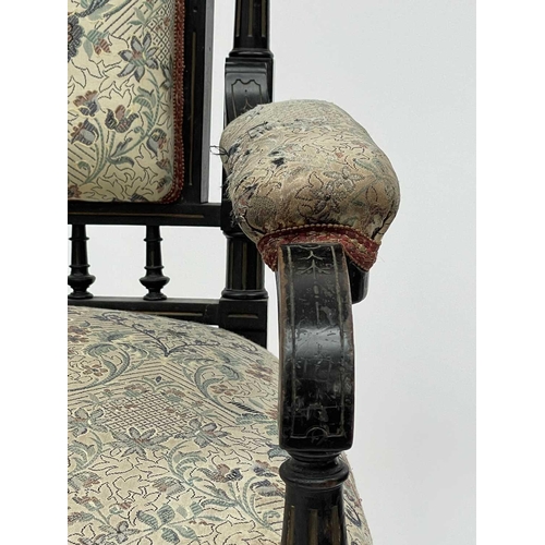 3060 - A Victorian ebonised aesthetic period armchair, the back with amboyna panels, with turned, gilt and ... 