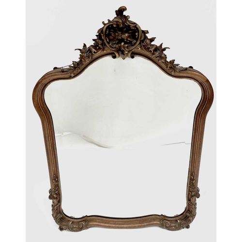 3087 - A late 19th century French walnut and parcel gilt wall mirror, with floral carved cresting and base,... 