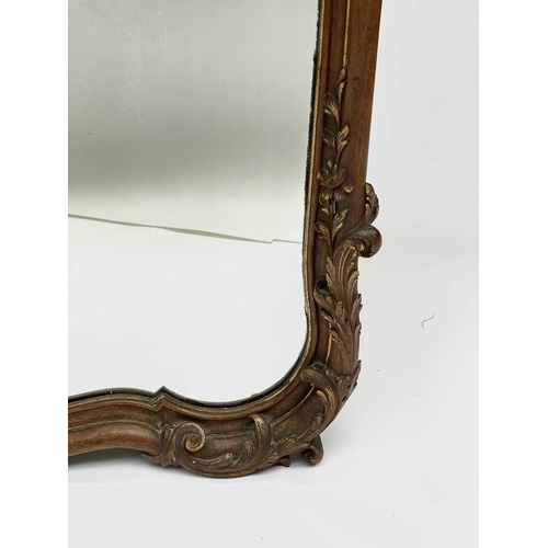 3087 - A late 19th century French walnut and parcel gilt wall mirror, with floral carved cresting and base,... 