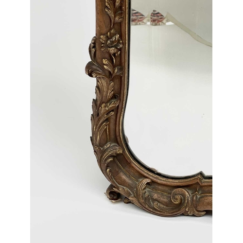 3087 - A late 19th century French walnut and parcel gilt wall mirror, with floral carved cresting and base,... 