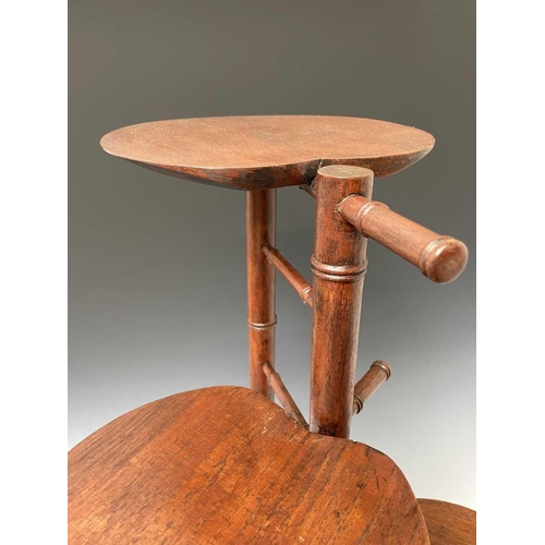 3088 - An Arts and Crafts mahogany stand, with three staggered leaf shape tiers and simulated bamboo turned... 