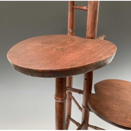 3088 - An Arts and Crafts mahogany stand, with three staggered leaf shape tiers and simulated bamboo turned... 