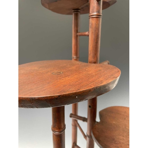 3088 - An Arts and Crafts mahogany stand, with three staggered leaf shape tiers and simulated bamboo turned... 