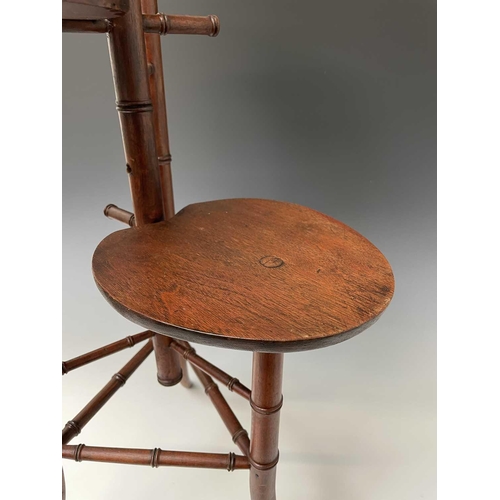 3088 - An Arts and Crafts mahogany stand, with three staggered leaf shape tiers and simulated bamboo turned... 