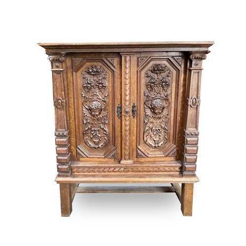 3096 - A Continental oak side cabinet, late 19th century, the two doors carved with cherub masks, fruit lad... 