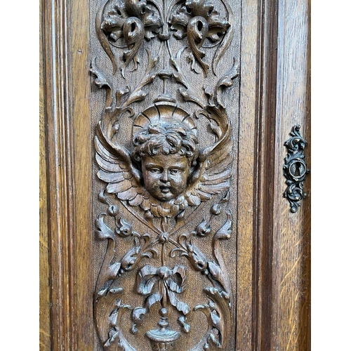 3096 - A Continental oak side cabinet, late 19th century, the two doors carved with cherub masks, fruit lad... 