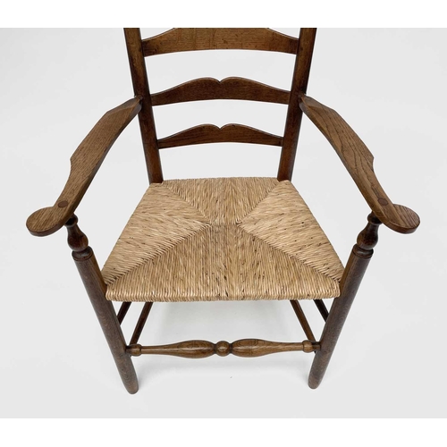 3104 - Robin Nance, An Arts and Crafts elbow ladder back elbow chair, with rush seat and turned supports, h... 