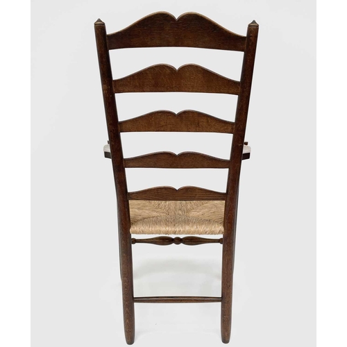 3104 - Robin Nance, An Arts and Crafts elbow ladder back elbow chair, with rush seat and turned supports, h... 