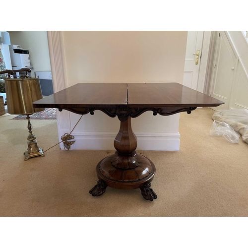 3105 - A William IV rosewood fold top tea table, raised on an octagonal baluster pillar and carved circular... 