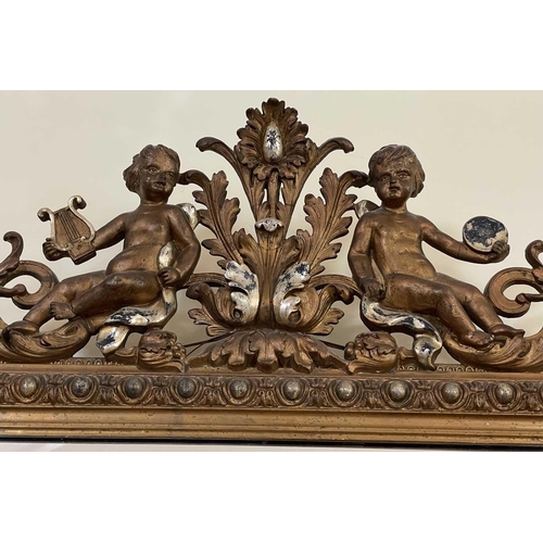 3107 - A French ornate gilt-gesso wall mirror, late 19th century, surmounted by two cherubs playing musical... 