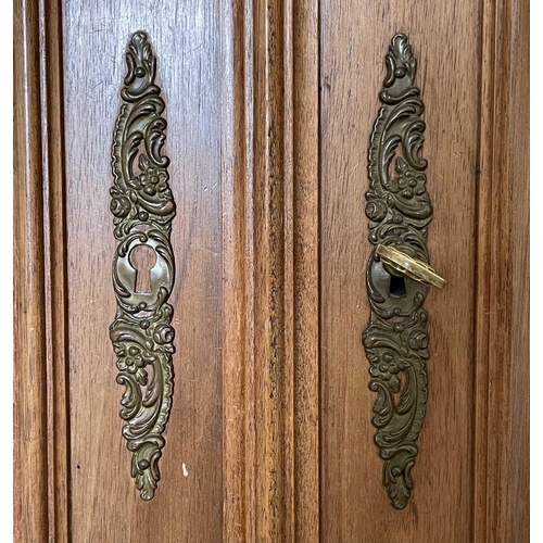 3132 - A French walnut armoire, late 19th century, with carved decoration, the two mirror doors enclosing a... 