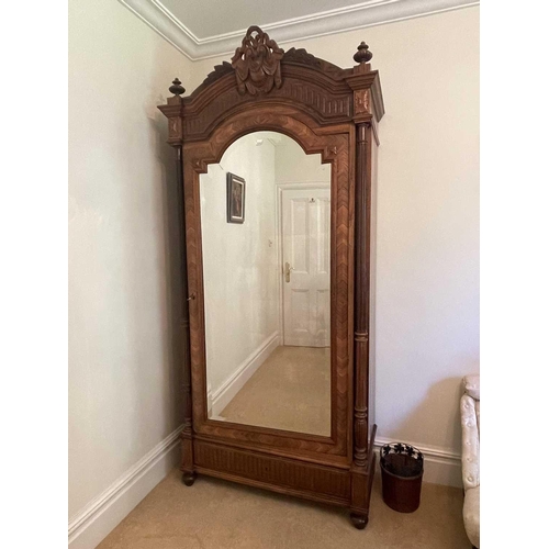 3139 - A French rosewood wardrobe, late 19th century, with arched and carved top, the mirrored door enclosi... 