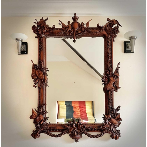 3143 - A mahogany ornate wall mirror, later 20th century, the frame carved with figures, dragons and milita... 