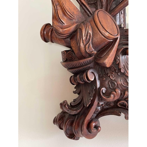 3143 - A mahogany ornate wall mirror, later 20th century, the frame carved with figures, dragons and milita... 