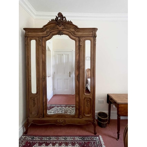 3145 - A French walnut wardrobe, late 19th century, the triple mirrored front with single door and raised o... 