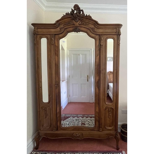 3145 - A French walnut wardrobe, late 19th century, the triple mirrored front with single door and raised o... 