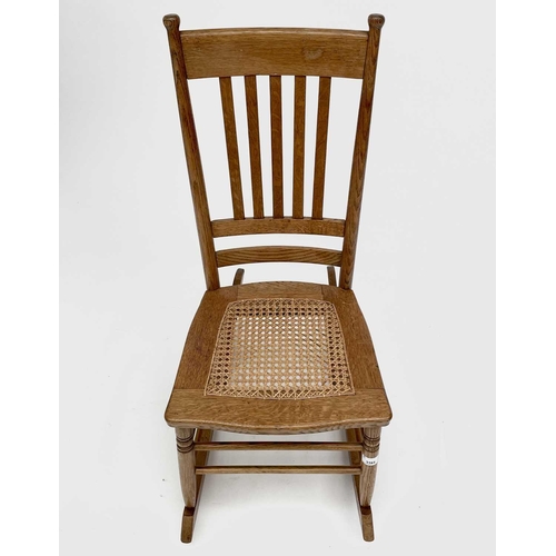 3165 - An elm rocking chair in the Arts and Crafts style with cane seat.