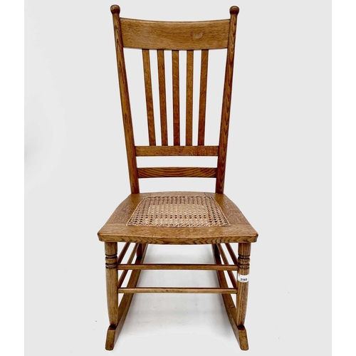 3165 - An elm rocking chair in the Arts and Crafts style with cane seat.