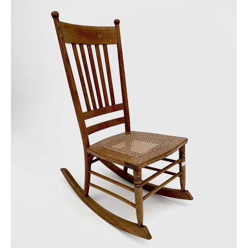 3165 - An elm rocking chair in the Arts and Crafts style with cane seat.