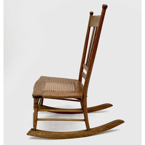 3165 - An elm rocking chair in the Arts and Crafts style with cane seat.