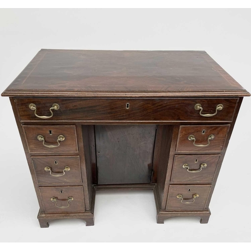 3185 - A George III mahogany kneehole desk, with a single frieze drawer above six drawers flanking a cupboa... 