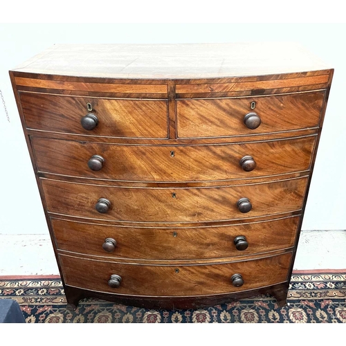 3190 - A Regency mahogany bow front chest of drawers, the satinwood crossbanded top above two short and fou... 